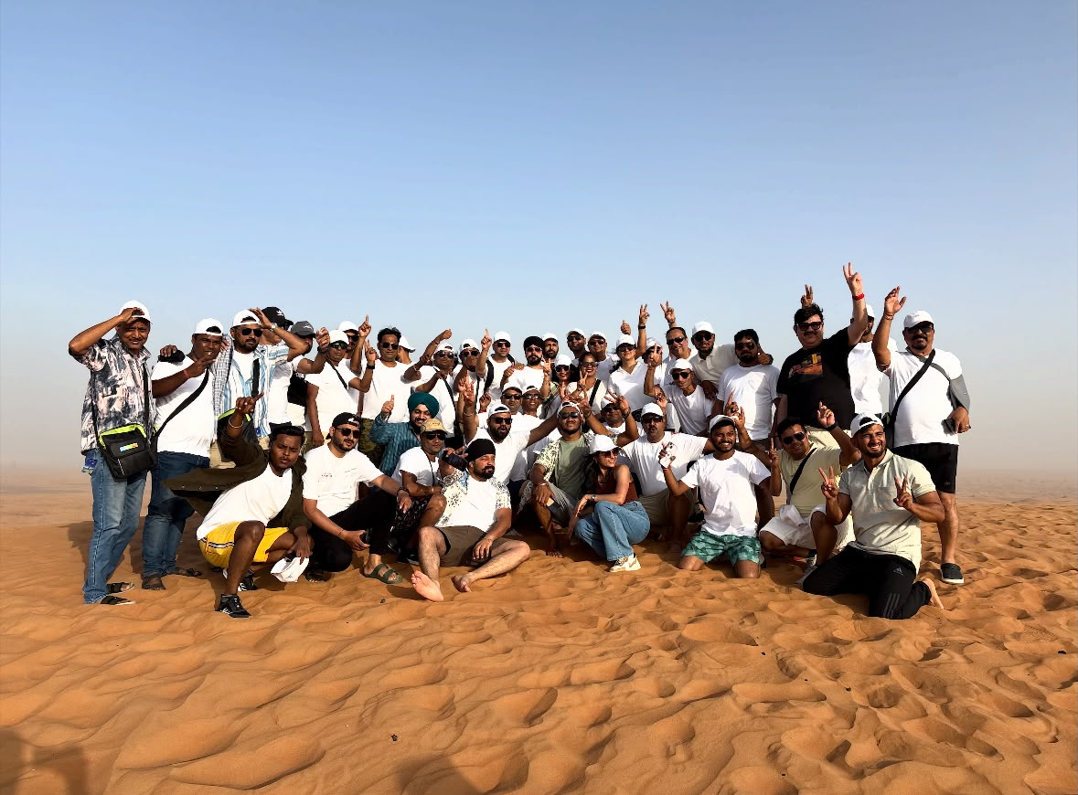 Traverse Globe travellers celebrating together on the Dubai desert dunes
